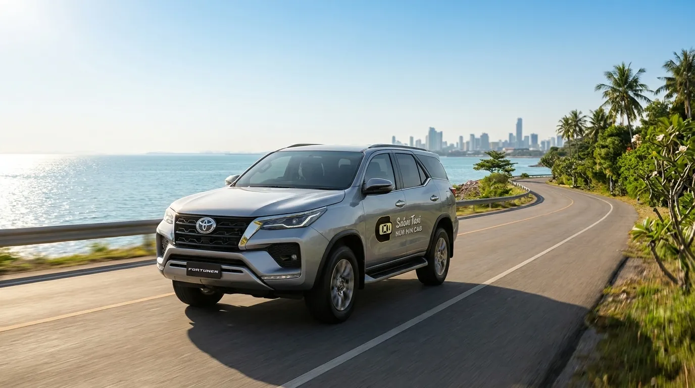 Modern Toyota Fortuner private taxi driving on a scenic coastal highway from Bangkok towards Bang Saphan for Koh Talu Pier.
